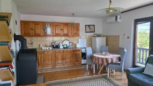 a kitchen with wooden cabinets and a table with a dining room at Holiday Home Nana in Bugojno