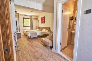 ein Schlafzimmer mit einem Bett und einem Badezimmer in einem Zimmer in der Unterkunft Kardes Hotel in Bursa