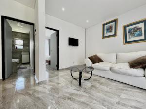 a living room with a white couch and a table at Number 12, Jadde apartments in Sandton