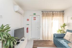 ein Wohnzimmer mit einer blauen Couch und einem Fernseher in der Unterkunft BeGuest Tiny Azure Apartament in Parede