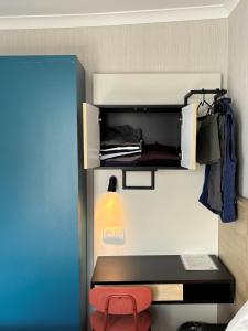 a small bed with a red stool in a room at HOTEL LEHOUCK in Koksijde