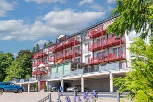 a red and white building with cars parked in front at Chalet Sonnenhang Oberhof in Oberhof