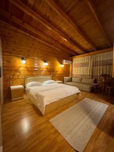 a bedroom with a large bed and a couch at Hotel Kocibelli POOL & SPA in Korçë +64 photos