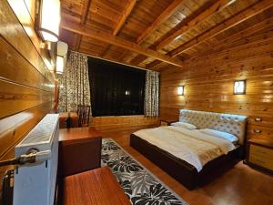 a bedroom with a bed in a wooden room at Hotel Kocibelli POOL & SPA in Korçë