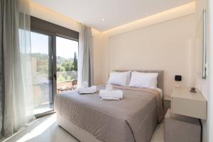 a bedroom with a bed with two towels on it at Glamour Residences 3-4 by CorfuEscapes in Análipsis