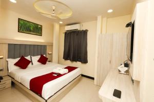 a bedroom with a bed with red and white pillows at Hotel Taj Palace - Near Mumbai Airport in Mumbai