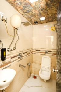 a bathroom with a toilet and a sink at Hotel Taj Palace - Near Mumbai Airport in Mumbai +11 photos