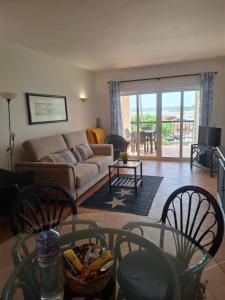 a living room with a couch and a table and chairs at Clube Alvor Ria - Waterfront luxury apartments with stunning views in Alvor