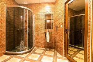 a bathroom with a shower, sink, and mirror at Discret Hotel & SPA in Vladaya