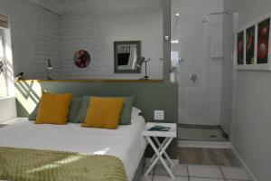 a bedroom with a bed with yellow pillows and a table at Amazing Grace B&B in Gansbaai