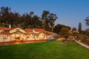 a house with a car parked in the yard at Rosewood by Nature Resorts and Stays in Ooty