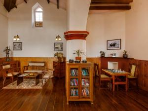 a living room with wooden floors and a table and chairs at Rosewood by Nature Resorts and Stays in Ooty