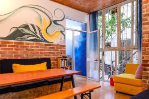 a living room with a table and a brick wall at Buff Hostel Tirana in Tirana