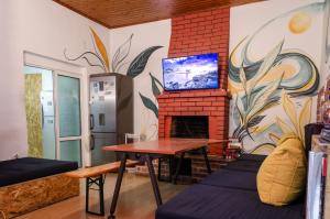 a living room with a fireplace and a tv on a wall at Buff Hostel Tirana in Tirana