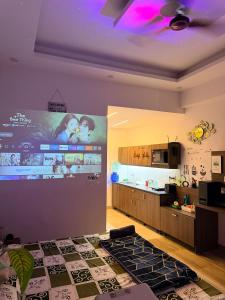 a kitchen with a large screen on the wall at GRiK STAY in Greater Noida