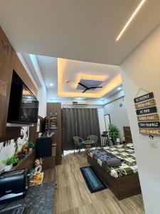 a bedroom with a bed and a tv and a table at GRiK STAY in Greater Noida +30 photos