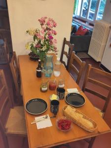 a wooden table with black plates and flowers on it at Mare Mars Chambres et table d'hotes in Mars-sur-Allier +10 photos