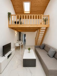 a living room with a couch and a staircase at AFY STAYS Boutique Apartments in Bucharest