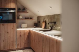 a kitchen with wooden cabinets and a sink at L'exclusif douceur in Aubel
