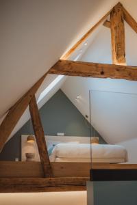 a room with a bed in the attic at L'exclusif douceur in Aubel