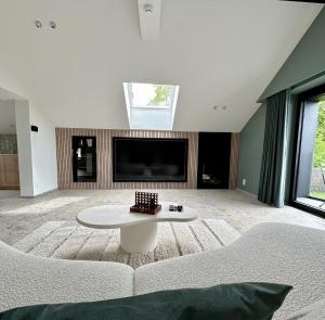 a living room with a white couch and a table at L'exclusif douceur in Aubel