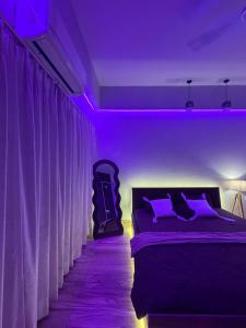 a bedroom with a bed with purple lighting at Novastay in Greater Noida +12 photos