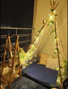 a room with a hammock and a bed with lights at Novastay in Greater Noida