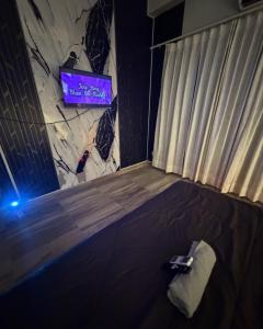 a room with a bed with a tv on the wall at Novastay in Greater Noida