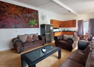 a living room with couches and a table at Anna Boeremeisie Guesthouse in Benoni