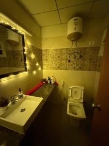 a bathroom with a sink and a toilet and a mirror at Novastay in Greater Noida