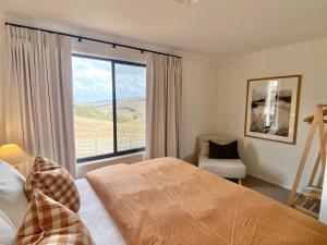 a bedroom with a bed and a large window at Oak Vue cottage in Korumburra