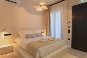 a bedroom with a bed with towels on it at Ichos Boutique Apartments in Volissos