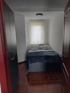 a small bedroom with a bed with a window at Virágos Lakás in Győr