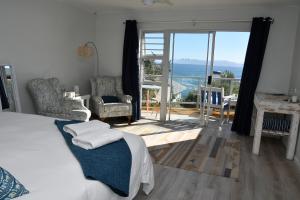 a bedroom with a bed and a view of the ocean at Amazing Grace B&B in Gansbaai