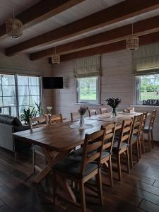 a dining room with a large wooden table and chairs at Arimaičių kaimo sodyba in Arimaičiai