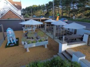 a group of picnic tables with umbrellas at The Dormy House Hotel in Cromer