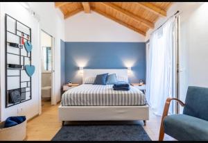 a bedroom with a bed and a blue accent wall at B&B I Menhir "nel Bosco" - Affittacamere in Lerici