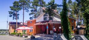 a house with an umbrella in front of it at Кафе Готель Люкс in Tsarivka