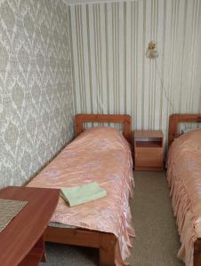 a room with two twin beds and a table and a table at Кафе Готель Люкс in Tsarivka