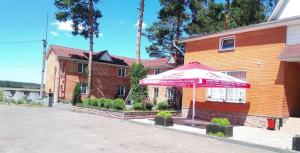 a pink umbrella sitting in front of a building at Кафе Готель Люкс in Tsarivka