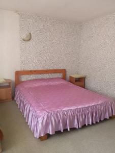 a bedroom with a bed with a pink bedspread at Кафе Готель Люкс in Tsarivka