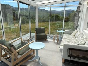 a living room with a couch and chairs and a large window at Glenmore Cottage - Waterville in Waterville +4 photos