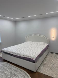 a bedroom with a white bed in a room at Guest House ak orgo in Bishkek