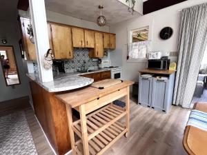 a kitchen with wooden cabinets and a counter top at Private Beach Escape - Chalet Ferdinand in Grand Barachois