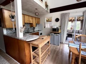 a kitchen with a counter and a table in it at Private Beach Escape - Chalet Ferdinand in Grand Barachois