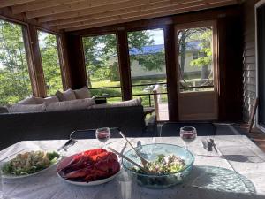 a table with two bowls of food and glasses of wine at Private Beach Escape - Chalet Ferdinand in Grand Barachois +21 photos