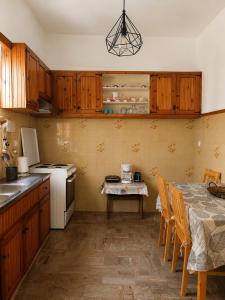 a kitchen with wooden cabinets and a table with chairs at Eftichia Apartment in Roda