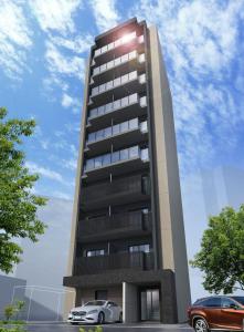 a tall building with cars parked in a parking lot at 乃宿-noyado-博多 in Fukuoka