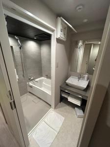 a bathroom with a sink and a tub and a toilet at 乃宿-noyado-博多 in Fukuoka