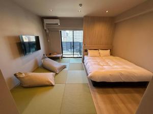 a bedroom with a large bed and a window at 乃宿-noyado-博多 in Fukuoka